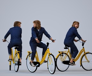 00252_Jet00011 Adult Caucasian man cycling through public space in transitional seasonal clothing