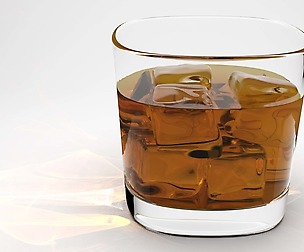 Whisky glass with liquid and ice cubes